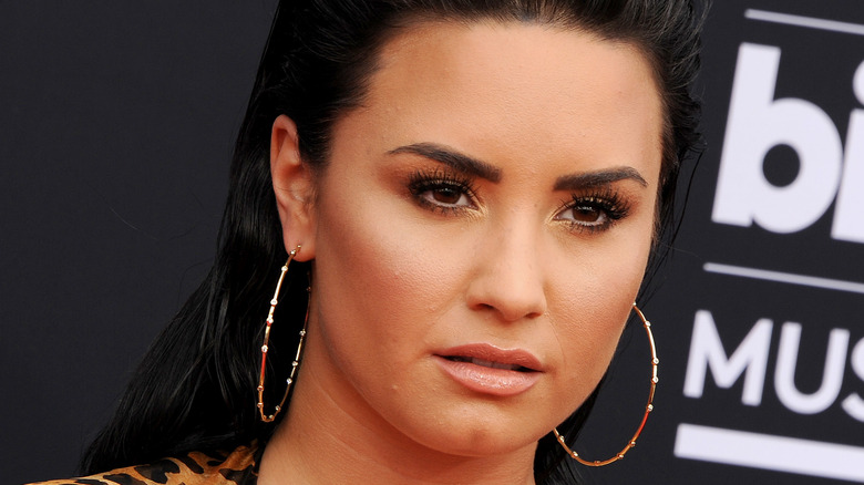 Demi Lovato wearing gold earrings