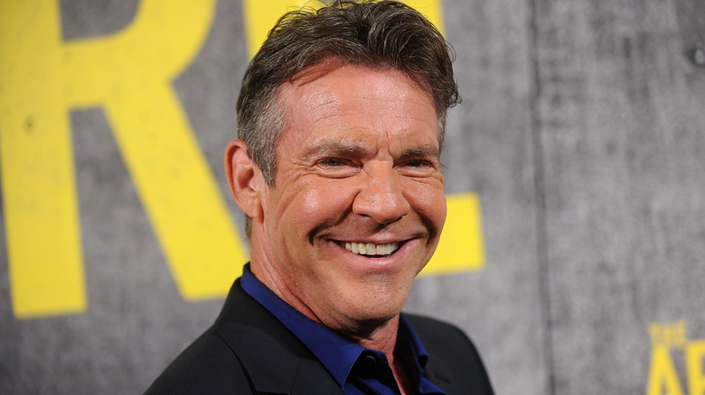 Dennis Quaid smiles in blue shirt