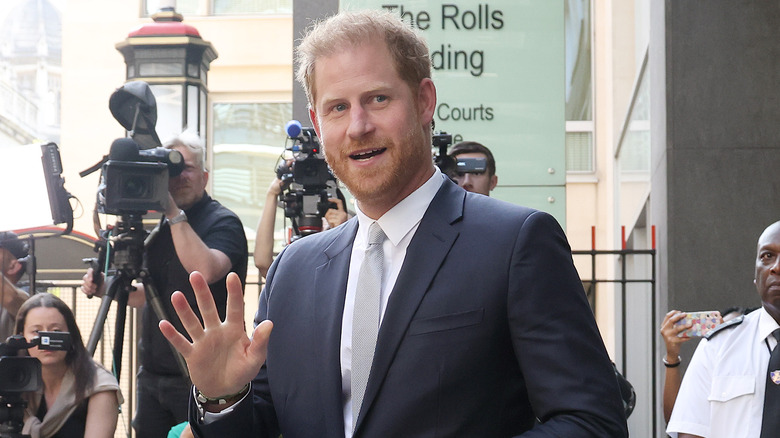 Prince Harry waves at photographers