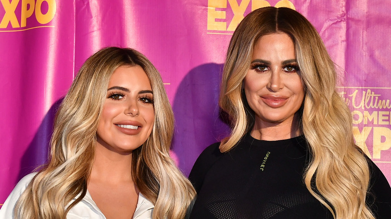 Brielle Biermann and Kim Zolciak smiling at red carpet event