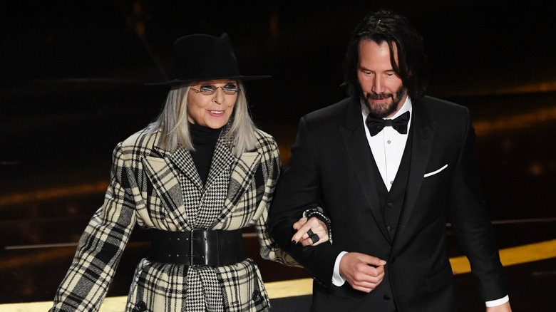 Diane Keaton and Keanu Reeves presenting an award on stage at the Oscars