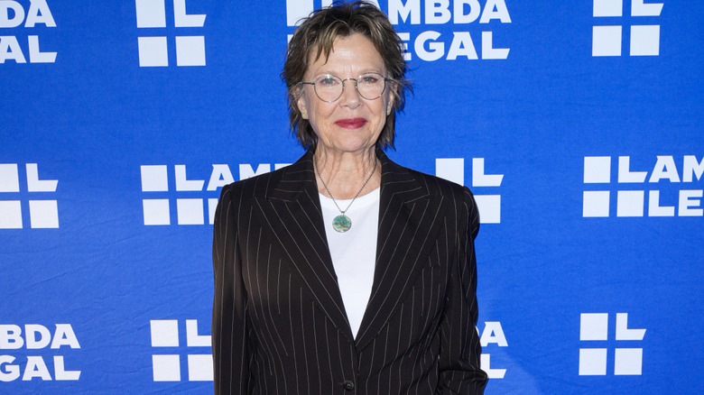 Annette Bening wearing a pinstripe jacket on the red carpet.