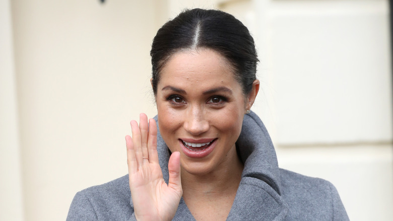 Meghan Markle smiling and waving