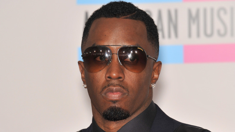 Sean 'Diddy' Combs posing at the American Music Awards in a black suit and aviators.