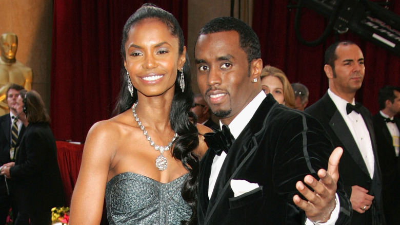 Kim Porter smiling, Diddy with his arm out