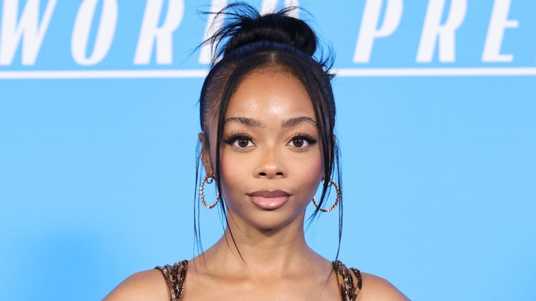 Wearing her hair in a bun, Skai Jackson gives the camera an intense gaze.