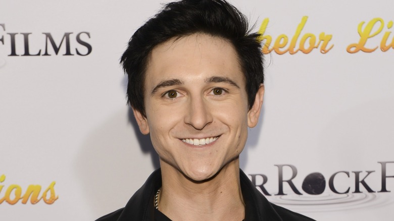 Mitchel Musso is all smiles as he looks directly into the camera.