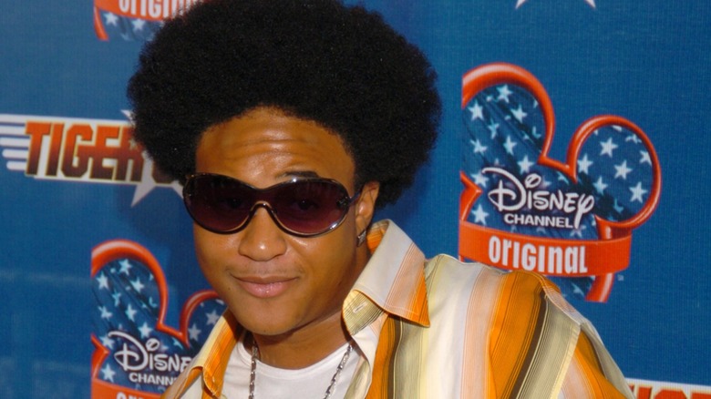 Wearing an afro look and a striped shirt, Orlando Brown makes a mischievous face.