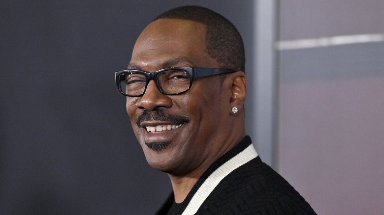 Eddie Murphy poses in black-frame glasses