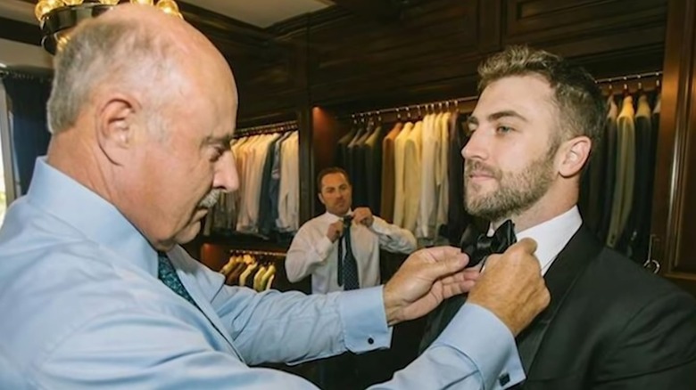 Dr. Phil McGraw helping Jordan McGraw with his tie