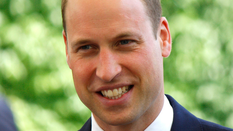 Prince William smiles in a navy suit.