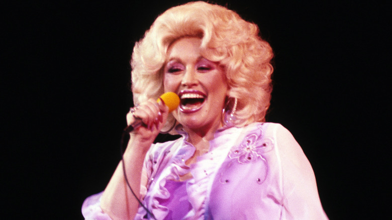 Dolly Parton laughing on stage.