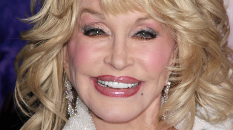 Dolly Parton smiles in a white outfit