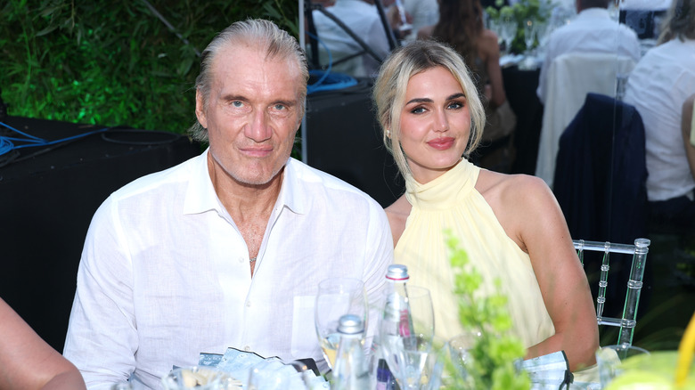 Dolph Lundgren and Emma Krokdal seated at a table at a dinner event