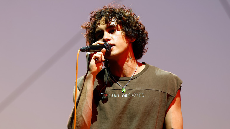 Dominic Fike holding a mic