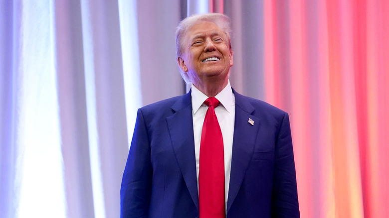 Donald Trump standing on stage and smiling