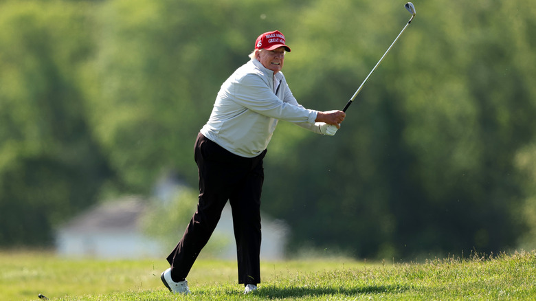 Donald Trump awkwardly swings his golf iron on a course during the pro-am prior to the LIV Golf Invitational - DC at Trump National Golf Club on May 25, 2023 in Sterling, Virginia.