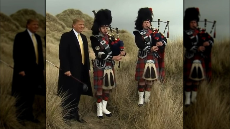 Donald Trump stands on a golf course with bagpipe players on May 27, 2010.