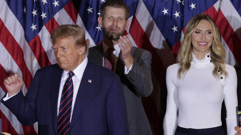 Donald Trump raising fist beside Eric and Lara Trump