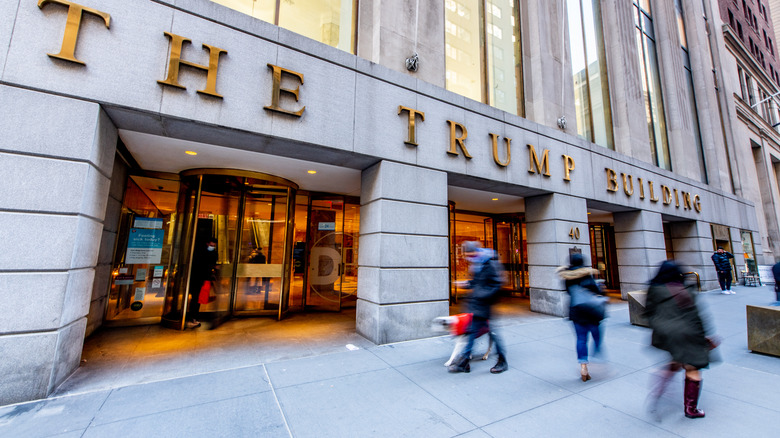 People walking along the Trump building