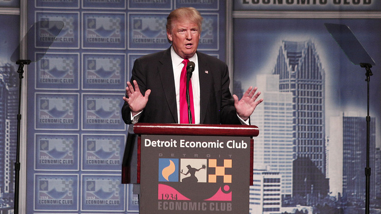 Donald Trump speaking at podium 
