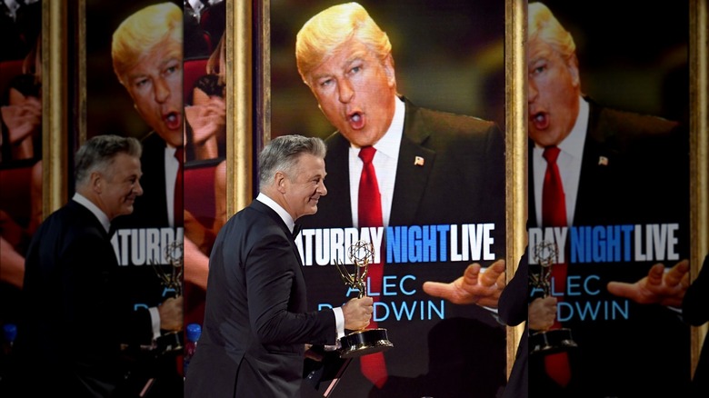 Alec Baldwin holding his Emmy for his portrayal of Donald Trump