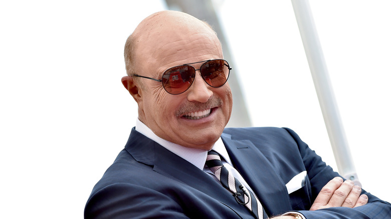 Dr. Phil McGraw smiling with his arms crossed