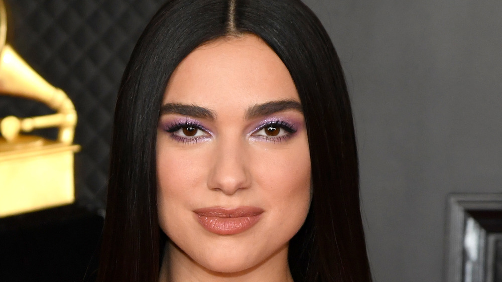 Dua Lipa smiling on the Grammys red carpet