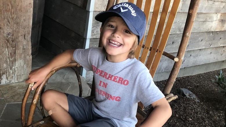 A young Duke sitting in a wooden chair and smiling.