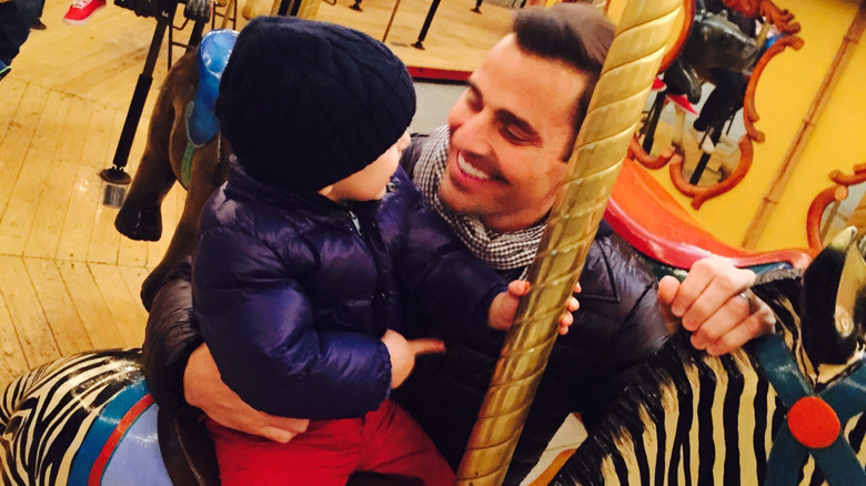 Bill holding Duke Rancic on a carousel