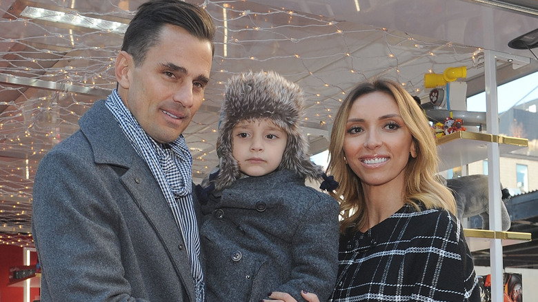 Bill Rancic, son Duke Rancic and Giuliana Rancic pose for a photograph duirng a Kohl's Holiday Gifting Truck event at Gansevoort Plaza on December 5, 2015 i