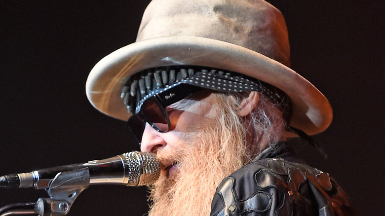 Dusty Hill sings into a microphone