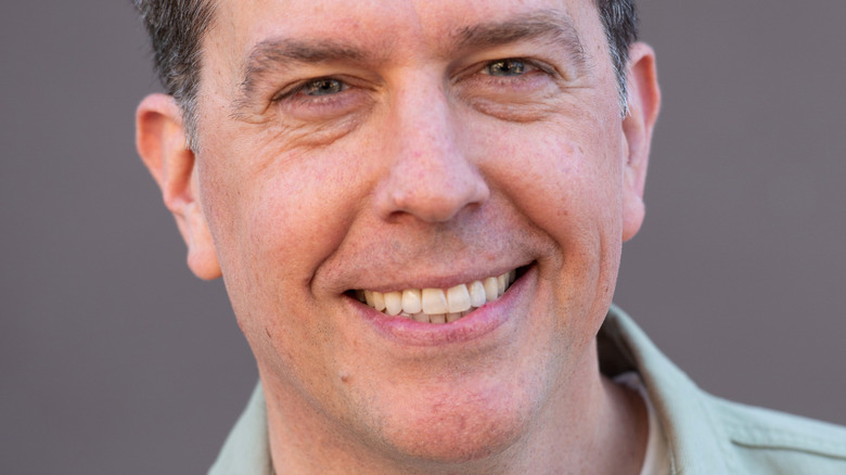 Ed Helms smiling, green shirt