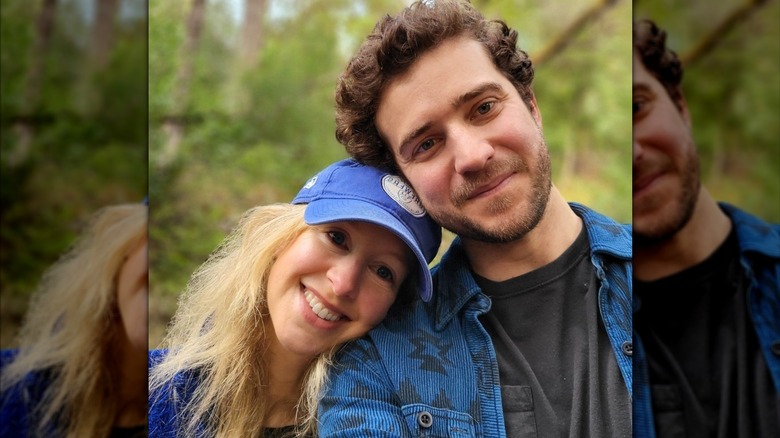 Elizabeth Holmes and Billy Evans leaning their heads together outdoors