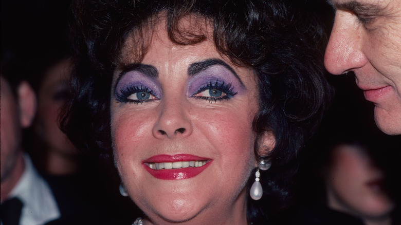 Elizabeth Taylor smiles for photographers in the early 1980s.