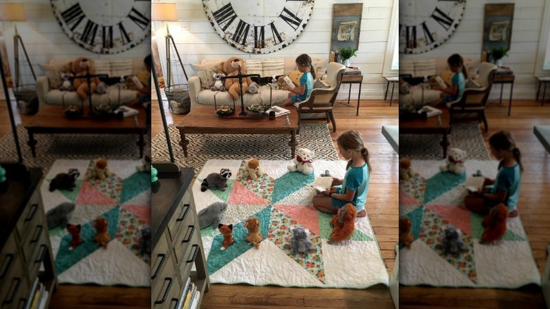 Ella and Emmie Gaines read on a quilt they sewed