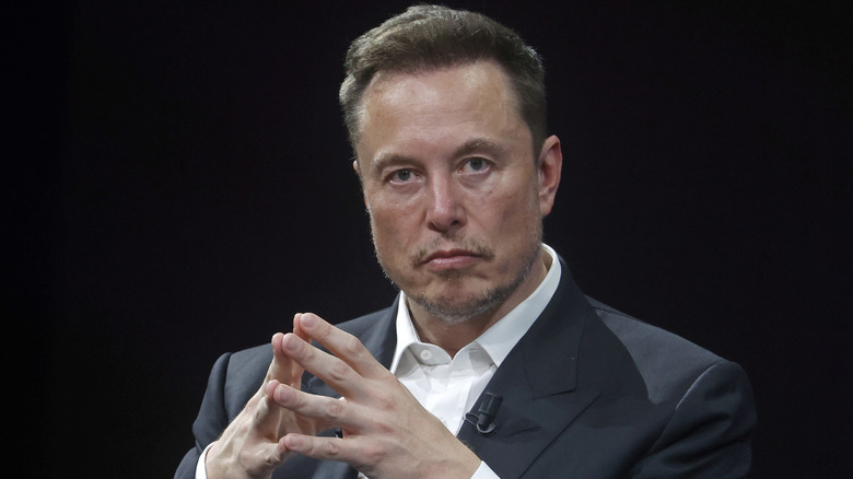 Elon Musk clasping his hands together