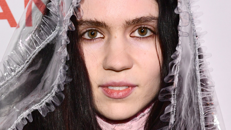 Grimes black hair wearing plastic veil