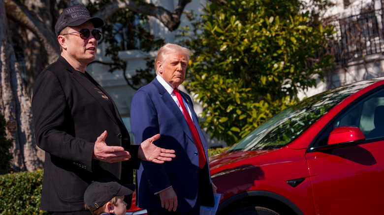 Elon Musk talking as Donald Trump stands next to him