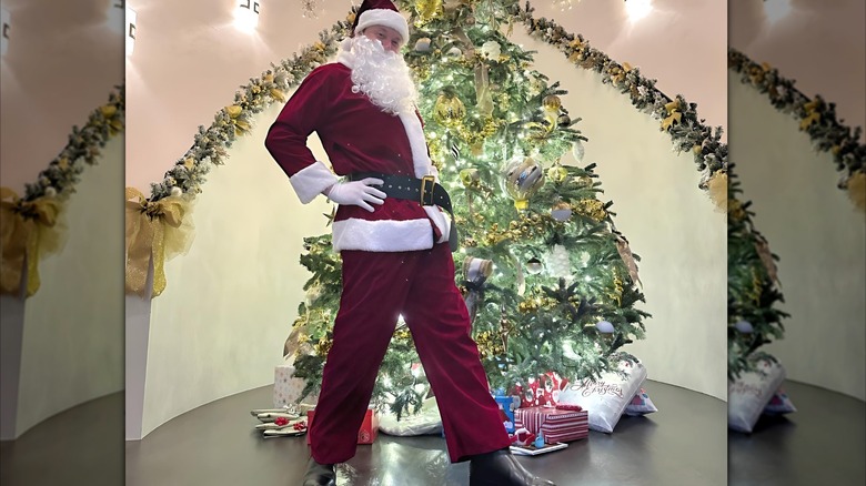 Elon Musk posing in a Santa Claus Outfit