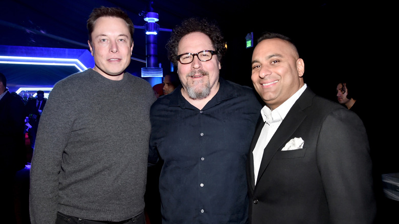Elon Musk posing with Jon Favreau and Russell Peters