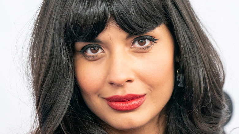 Jameela Jamil smiles with red lipstick