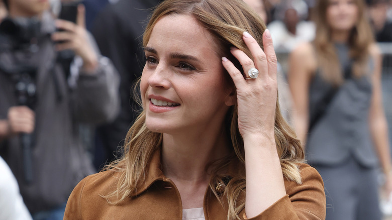 Emma Watson looking into distance and showing ring at Fashion Week