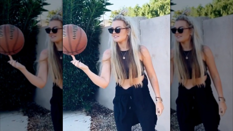 Erika Kirk spinning a basketball in a sheer bralette.