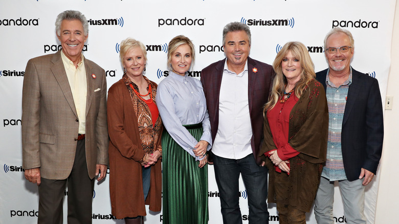The cast of The Brady Bunch, Barry Williams, Eve Plumb, Maureen McCormack, Christopher Knight, Susan Olsen, and Mike Lookinland pose together.