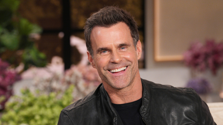 Cameron Mathison smiling in front of the camera.