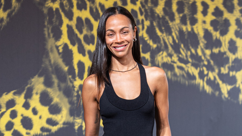 Zoe Saldaña smiling while posing in a black dress at the Locarno Film Festival