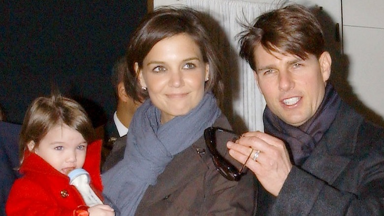 Katie Holmes carrying Suri Cruise, Tom Cruise smiling