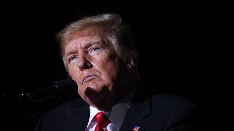 Donald Trump frowning behind microphone