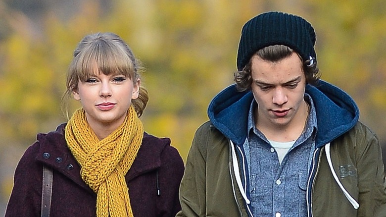 Taylor Swift and Harry Styles walking side by side outdoors